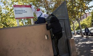 Dos menores migrantes saltan el muro para acceder al Centro de Primera Acogida de Menores de Hortaleza, en Madrid.- JAIRO VARGAS
