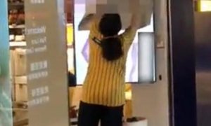 Una trabajadora de Ikea intenta tapar la pantalla del escaparate de una de las tiendas del gigante sueco en Hong Kong.