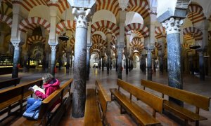 Una turista leen sentada en la Mezquita de Córdoba. AFP/Jorge Guerrero
