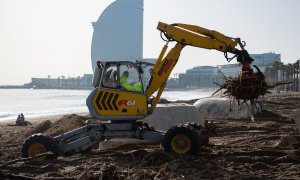 Un operario recoge parte de los desperfectos provocados por el temporal 'Gloria' en la playa de Barcelona. (Josep Lago-AFP)