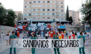 31/05/2020.- Miembros del personal sanitario del Hospital Gregorio Marañón posan con una pancarta en la que se lee ""Sanitarios necesarios"" durante una concentración este lunes en el exterior del hospital en Madrid, en la primera jornada de la Comunidad