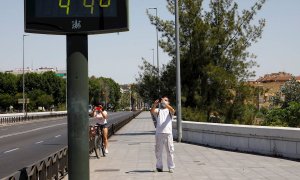 Unas personas fotografían un termómetro de calle en Córdoba que indica 44 grados. EFE/Archivo
