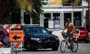 Un hombre y un niño fueron registrados este viernes al recorrer, en bicicleta y sin protección facial, el paseo turístico de Ocean Drive, en Miami Beach (Florida, EE.UU.). EFE/Giorgio Viera