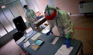Dos profesionales sanitarias preparan el material para realizar pruebas PCR. EFE/Enric Fontcuberta/Archivo