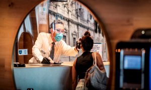 Un recepcionista de hotel toma la temperatura a una huesped por la pandemia de coronavirus. EFE/ José Manuel Vidal/Archivo