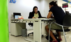Un ciutadà atén les explicacions d'una treballadora del Servei d'Ocupació de Catalunya. ANDREA ZAMORANO / ACN