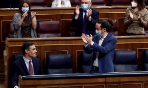 El presidente del Gobierno, Pedro Sánchez, es aplaudido por el vicepresidente segundo, Pablo Iglesias (d) y sus compañeros de partido tras su intervención en la moción de censura de VOX al gobierno de coalición, en el Congreso de los Diputados este miérco