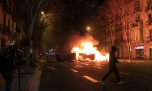 Un manifestant passa pel davant d'una barricada de contenidors cremant a Barcelona el 18 de febrer del 2021.