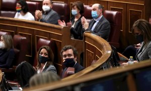 Parlamentarios aplauden durante el pleno del Congreso de los Diputados, a excepción de los diputados de Vox.