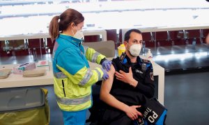 Un policía recibe la primera dosis durante el primer día de vacunación contra la covid-19 en el Wanda Metropolitano