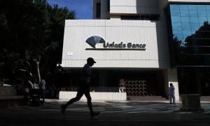 Un hombre pasa por las inmediaciones de la sede de Unicaja Banco en Málaga. E.P./Álex Zea