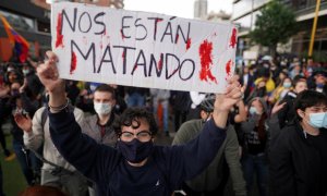 Un manifestante en sostiene una pancarta en la que se lee "Nos están matando" en Bogotá, Colombia