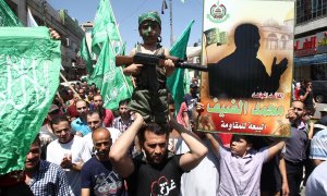 Foto de archivo de agosto de 2014, de una manifestación en Hebrón (Cisjordania) contra Israel, en la que un manifestante sostiene un supuesto retrato del jefe militar de Hamas, Mohammed Deif (derecha). AFP/Hazem Baderhazem