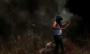 Un manifestante lanza piedras con su honda a miembros de las tropas israelíes después de una protesta contra unos asentamientos israelíes, este viernes en Nablus, Palestina.