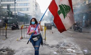 Una mujer sostiene una bandera de Líbano en Beirut.