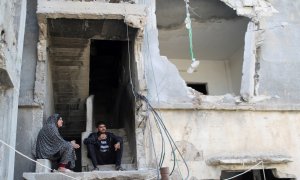 Palestinos se sientan sobre los escombros de su casa que fue destruida en los ataques aéreos israelíes durante los combates israelí-palestinos, en Gaza, el 9 de junio de 2021.