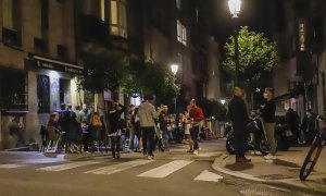 Transeúntes caminan por una vía durante la primera noche de la reapertura del ocio nocturno con condiciones en Galicia
