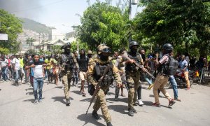 Policías haitianos escoltan a un grupo de personas mientras conducen detenidos a dos extranjeros en Puerto Principe , Haití