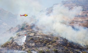 Un helicóptero en labores de extinción del incendio declarado este viernes en el parque natural del Cap de Creu.