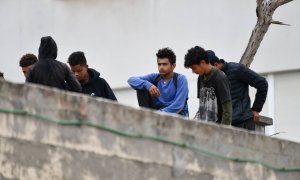 Varios menores migrantes, en el tejado de una nave industrial, a 27 de agosto de 2021, en Ceuta, (España).