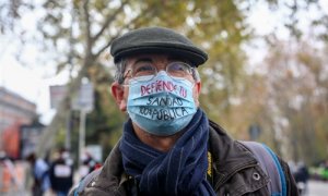 Un hombre lleva una mascarilla donde se lee "defiende tu sanidad 100% pública" durante una manifestación de la Marea Blanca en Madrid, a 29 de noviembre de 2020.