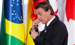 El presidente de Brasil, Jail Bolsonaro, se quita la mascarilla a su llegada a la cumbre del G20 en Roma el 30 de octubre de 2021.