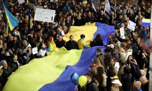 Gente protesta con una larga bandera ucraniana contra la invasión rusa de Ucrania y en apoyo de Ucrania, en Tel Aviv