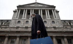 Un hombre con mascarilla pasa por delante del edificio de la sede del Banco de Inglaterra (BoE, en sus siglas en inglés), en la City de Londres. REUTERS/Toby Melville