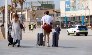 Dos turistes amb les maletes per la Barceloneta.