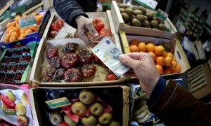 Un cliente paga con un billete de 5 euros en un puesto de fruta de un mercado en Niza (Francia). REUTERS/Eric Gaillard