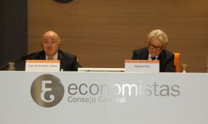 El vicepresidente del BCE, Luis de Guindos (i), junto al presidente del Consejo General de Economistas de España (CGE), Valentín Pich (d), durante un evento informativo de los economistas, en Madrid.  EFE