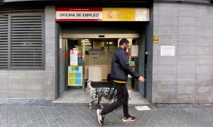 Un hombre pasa con su perro por la oficina de empleo de Acacias, a 4 de octubre de 2022, en Madrid (España).