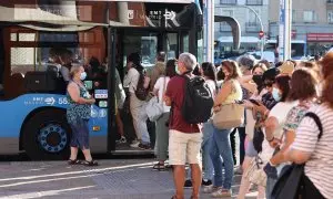Varias personas, con mascarilla, hacen cola para subir a un autobús de la Empresa Municipal de Transportes madrileña (EMT), a 1 de septiembre de 2022, en Madrid (España).