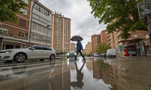 Un hombre se protege de la lluvia bajo un paraguas en Teruel, a 24 de mayo de 2023.