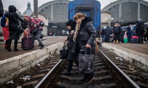 Dos mujeres cruzan las vías de la estación de tren de Leópolis para huir a la vecina Polonia tras la invasión rusa de Ucrania, a 4 de marzo de 2022.
