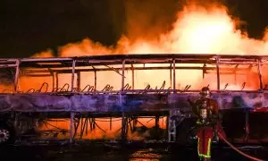 Los bomberos tratan de extinguir las llamas de un autobús durante la cuarta noche de disturbios por la muerte de un joven negro, en Nanterre a 1 de julio de 2023