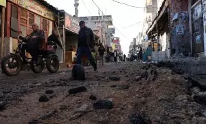 Los palestinos avanzan por una calle dañada después de un bombardeo del Ejército israelí en Cisjordania, el 21 de noviembre de 2023.- EFE