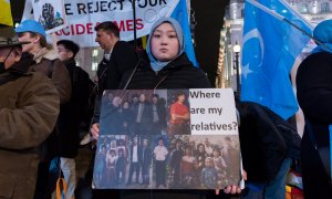 Una mujer uigur sostiene un cartel con fotografías de sus familiares, en una protesta en Piccadilly Circus, a 3 de febrero de 2022 en Londres, Inglaterra.