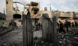 Un grupo de palestinos inspeccionan los restos de una casa destruida tras los ataques israelíes contra la Franja de Gaza, a 8 de diciembre de 2023.