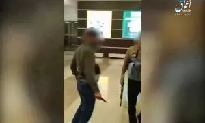 Fotograma del vídeo difundido por Estado Islámico a través de la agencia Amaq en el que se ve a un hombre con un cuchillo después de degollar a un herido y a otro con un arma automática
