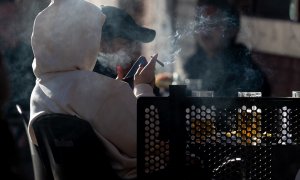 Una persona fumando en una terraza, a 27 de diciembre de 2023, en Madrid.