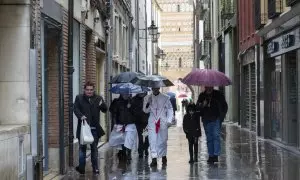 Varias personas caminando bajo la lluvia en Teruel, a 31 de marzo de 2024