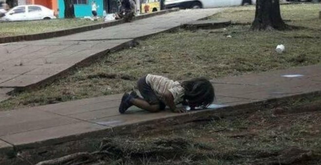 La fotografía de un niño bebiendo agua del suelo que refleja la miseria de los menores guaraníes