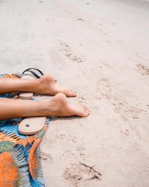 Piernas al sol en la playa