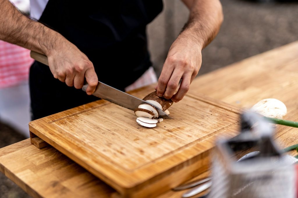 Cocinero cortando setas