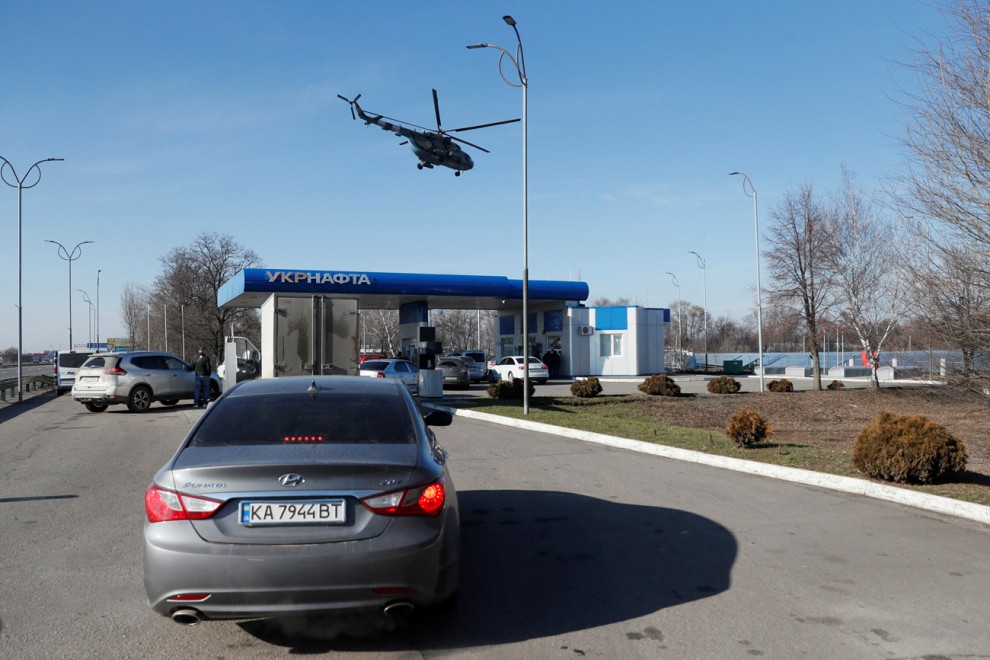 Un helicóptero militar ucraniano sobrevuela una gasolinera, después de que el presidente ruso, Vladimir Putin, autorizara una operación militar en Ucrania, en las afueras de la ciudad de Dnipro, Ucrania.