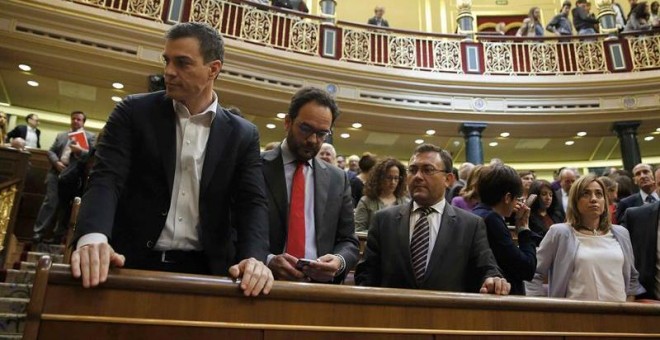 El secretario general del PSOE, Pedro Sánchez; el portavoz del partido en el Congreso, Antonio Hernando, y los diputados socialistas Miguel Ángel Heredia, Isabel Rodríguez (de espaldas) y Carme Chacón (i-d) en sus escaños al finalizar hoy en la Cámara el