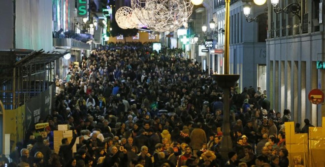 La madrileña calle de Preciados, una de las principales arterias comerciales de la capital, abarrotada de peatones durante los días previos a la Navidad. EFE