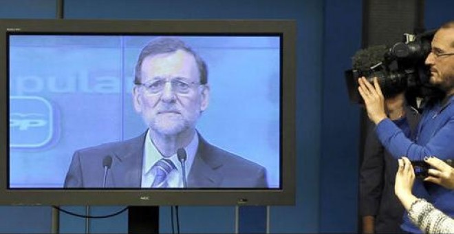 Los periodistas siguen un discurso de Rajoy desde la sala de prensa. EFE/J.J. Guillén