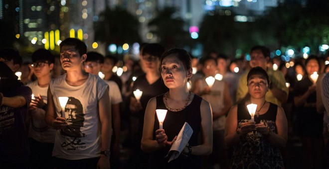 Miles personas sostienen velas mientras participan en una vigilia con motivo del 26 aniversario de la matanza de Tiananmen, en el Victoria Park de Hong Kong, China. EFE